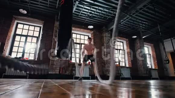 在健身房训练的运动员用绳子来训练他的手视频的预览图