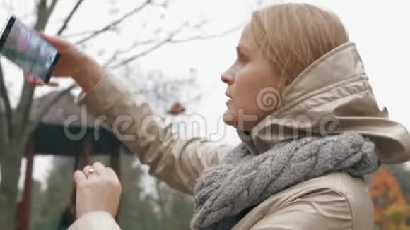 秋天和宝宝一起散步的女人在拍罗万树的照片视频的预览图