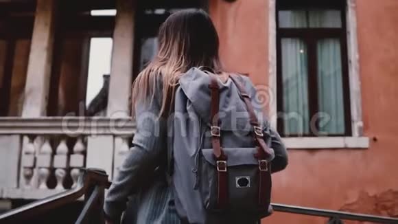 镜头跟随美丽的微笑旅游妇女与专业相机在老威尼斯街道慢动作拍照视频的预览图