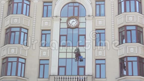 一个人在高处洗窗户服务清洁摩天大楼的窗户摩天大楼上的一个窗户垫圈视频的预览图
