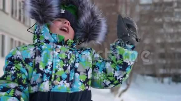 一个小孩子在冬季公园散步玩和微笑的婴儿挥手主动休息和游戏视频的预览图