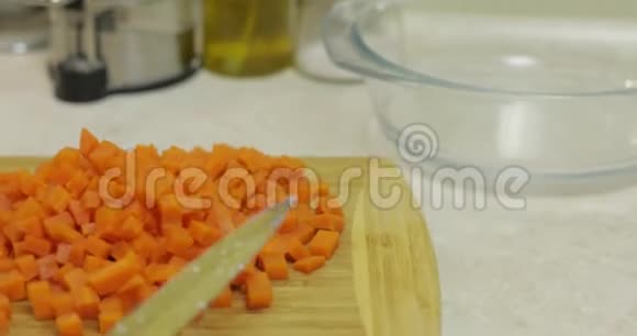 女性家庭主妇用手将胡萝卜片放入沙拉盘中视频的预览图