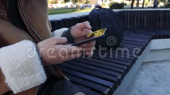街上坐在智能手机里的女孩视频的预览图