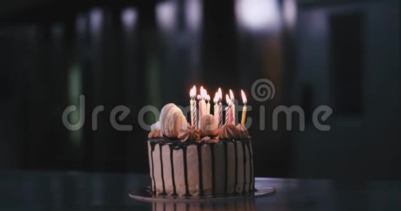在一家商业面包店厨房里用生日蜡烛做巧克力蛋糕的特写视频的预览图