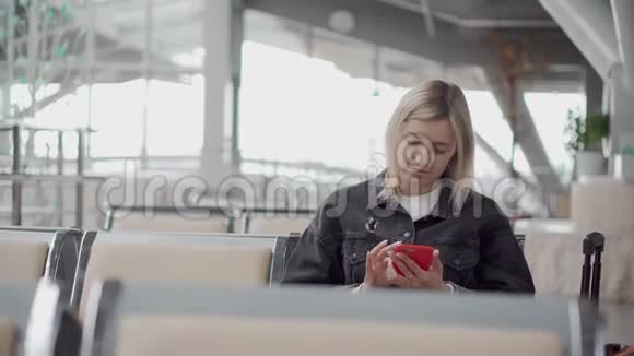机场有智能手机的金发女孩视频的预览图