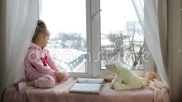 女孩坐在窗台上看上去视频的预览图