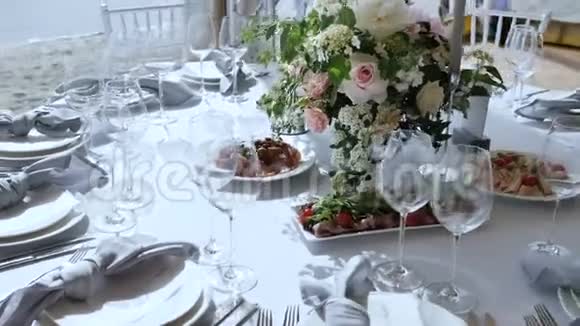 宴会上有大桌子白色桌布各种美味菜肴鲜花玫瑰蜡烛装饰视频的预览图