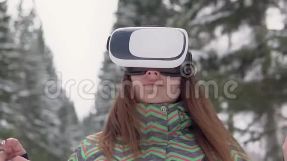 一个年轻的女人在雪地森林里的街道上使用电子虚拟现实眼镜视频的预览图