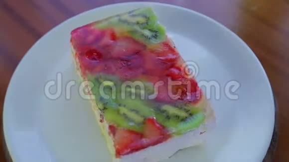 白色盘子上的果冻水果蛋糕从上面旋转成一个圆圈视频的预览图
