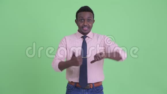 困惑的年轻非洲商人在竖起大拇指和竖起大拇指之间做出选择视频的预览图