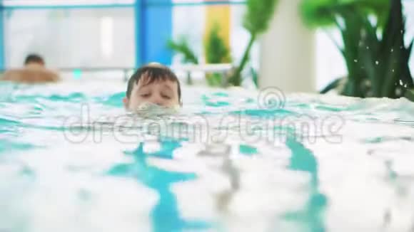 少年在泳池里游泳只有他的头伸出水面视频的预览图