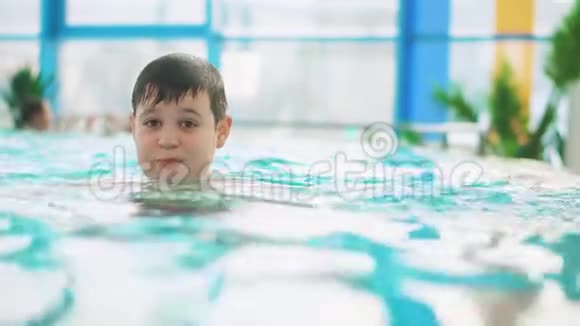 少年在游泳池里游泳他用头潜水视频的预览图