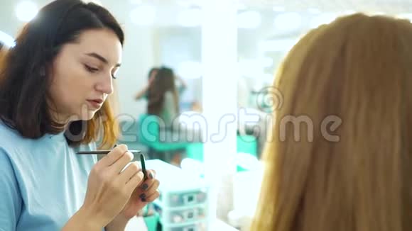 一张女人用化妆对年轻顾客进行慢动作的照片视频的预览图