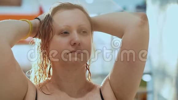 疲惫的中年妇女的画像她在一个湿发的水上公园里双手抱在头上视频的预览图
