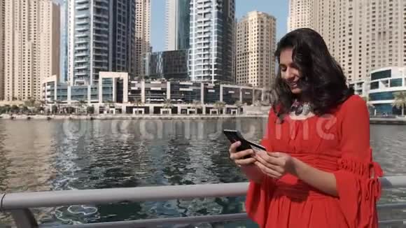 在迪拜码头有电话和信用卡的印度女孩视频的预览图