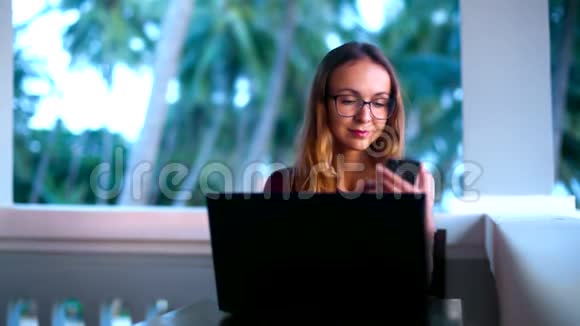 戴眼镜的女孩在手机上搜索棕榈树视频的预览图
