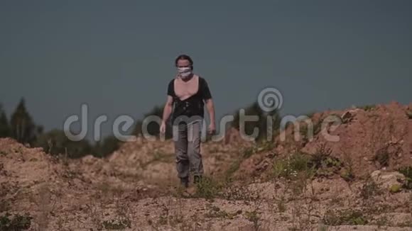 一个穿着破烂衣服的陌生人穿过沙漠寻找绿洲视频的预览图