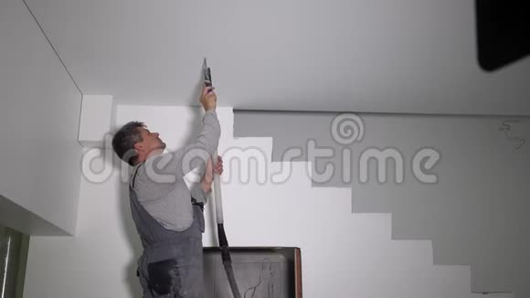 电工在石膏板天花板上看到一个圆洞视频的预览图