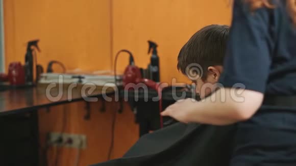 理发师梳男少年做一个时尚发型视频的预览图