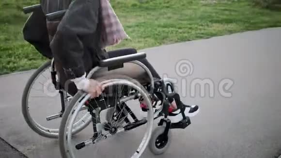 残疾妇女正在户外乘坐无效的马车身体特写视频的预览图