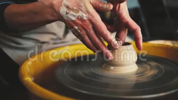 陶工在制陶车间的轮子手工陶器里面手在陶轮上工作塑造一个粘土视频的预览图