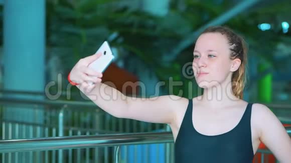 一个穿着黑色泳衣的年轻女孩在公共水上公园自拍视频的预览图