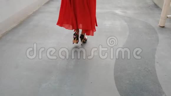 在迪拜码头穿着一件鲜红长裙的黑发女孩穿过大桥视频的预览图