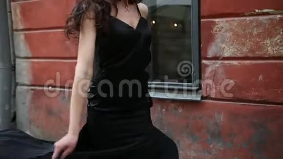女孩黑发穿着黑色连衣裙妆容鲜艳戴着皇冠走在街上视频的预览图