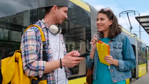 年轻人在电车公共交通工具上与一个女孩见面交谈视频的预览图