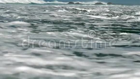 巨大的海浪在棕色岩石上缓慢地翻滚视频的预览图