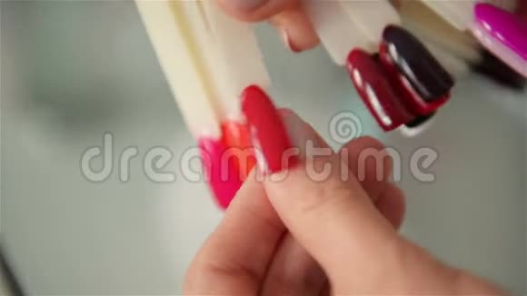 慢动作手选择指甲样本特写一套五彩收藏品人工指甲色标和女人视频的预览图