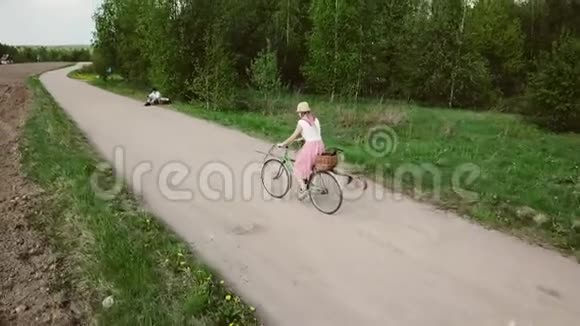 穿裙子的年轻女子骑自行车视频的预览图