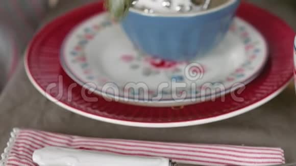 圣诞餐桌装饰节日餐桌设置女性的双手为圣诞节装饰餐桌视频的预览图
