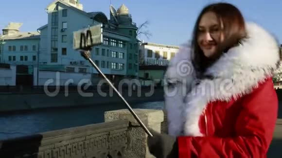 穿红色夹克的女孩在街上摆姿势自拍视频的预览图