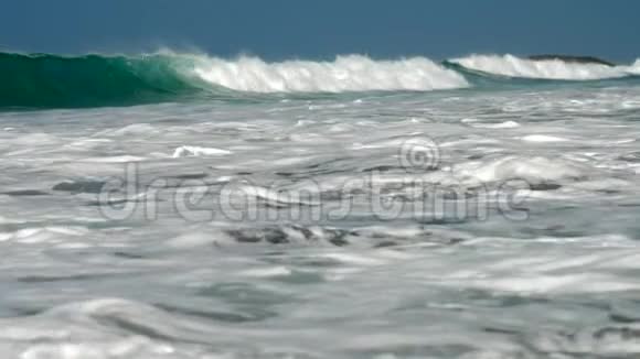 巨大的海浪在蓝天下流动白色的泡沫视频的预览图