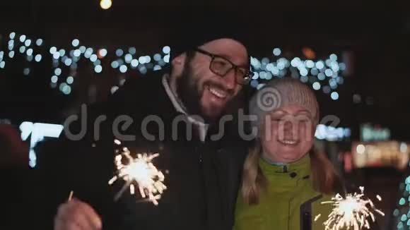 幸福的一对夫妻相约新年又亲冬天在外面他们手里拿着火花反对视频的预览图