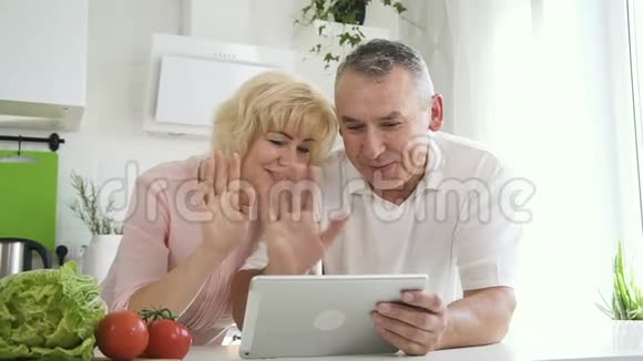年长夫妇用平板电脑和家人交谈视频的预览图