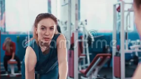 镜子里的倒影年轻的健身女孩用哑铃做运动视频的预览图