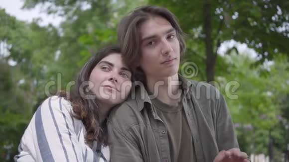 肖像漂亮的爱情夫妇穿着休闲服装在一起在公园里有一个约会情侣们坐在视频的预览图