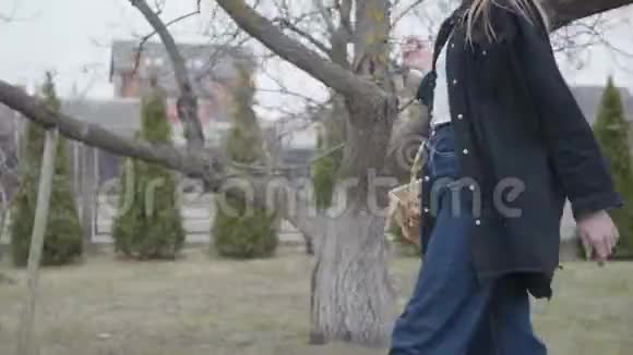 一个面目全非的年轻女子手里拿着刷子提着胡桃木的柳条筐走着漫不经心的迷人艺术家视频的预览图