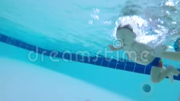 一个男孩在水下游泳抓住一个玩具在水下近距离视频的预览图