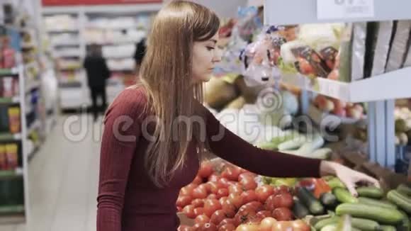 小女孩在超市的杂货店买蔬菜然后放进塑料袋里视频的预览图