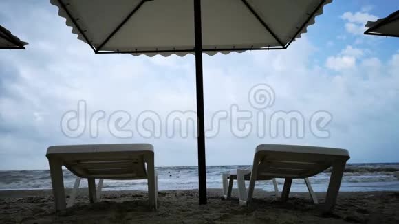 海滩上的暴风雨大灰波和凉爽的天气空阳床作为自然的概念视频的预览图
