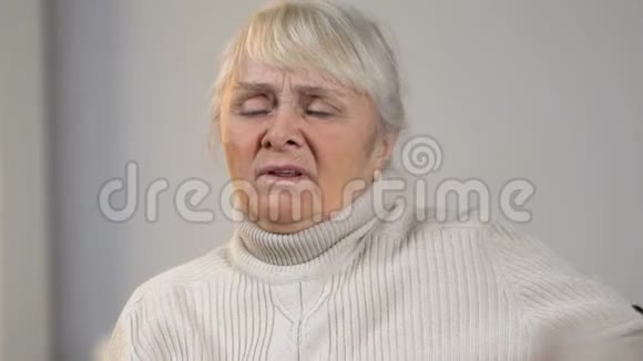 老年残疾妇女心脏疼痛看着桌上的药物视频的预览图