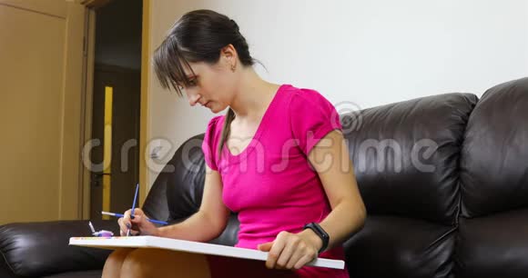 一个年轻的女人坐在一张皮沙发上腿上拿着一张帆布视频的预览图