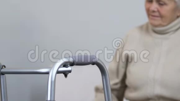 护士帮助患有关节炎的老年女士站起来拿走架视频的预览图