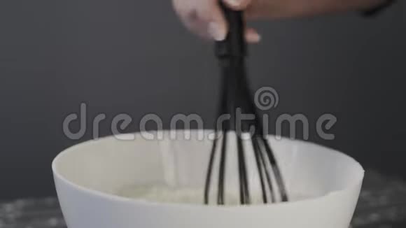 特写镜头女人把面粉倒在碗里用搅拌器搅拌配料视频的预览图