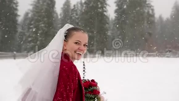 年轻的新娘跑到森林里要求跟随她并在大雪下在滑雪胜地村玩冬季视频的预览图
