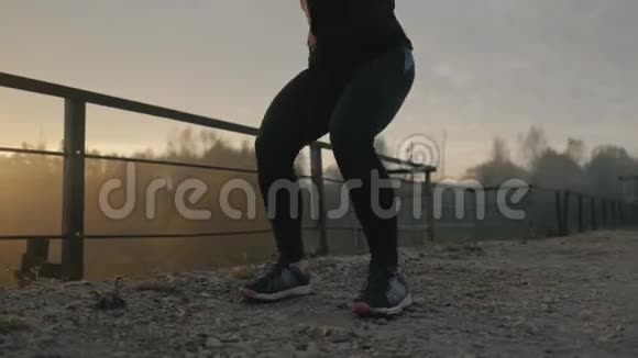 年轻的肌肉健身女子在大自然中做蹲式运动视频的预览图
