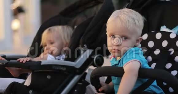 悲伤的孩子们坐在婴儿车里视频的预览图
